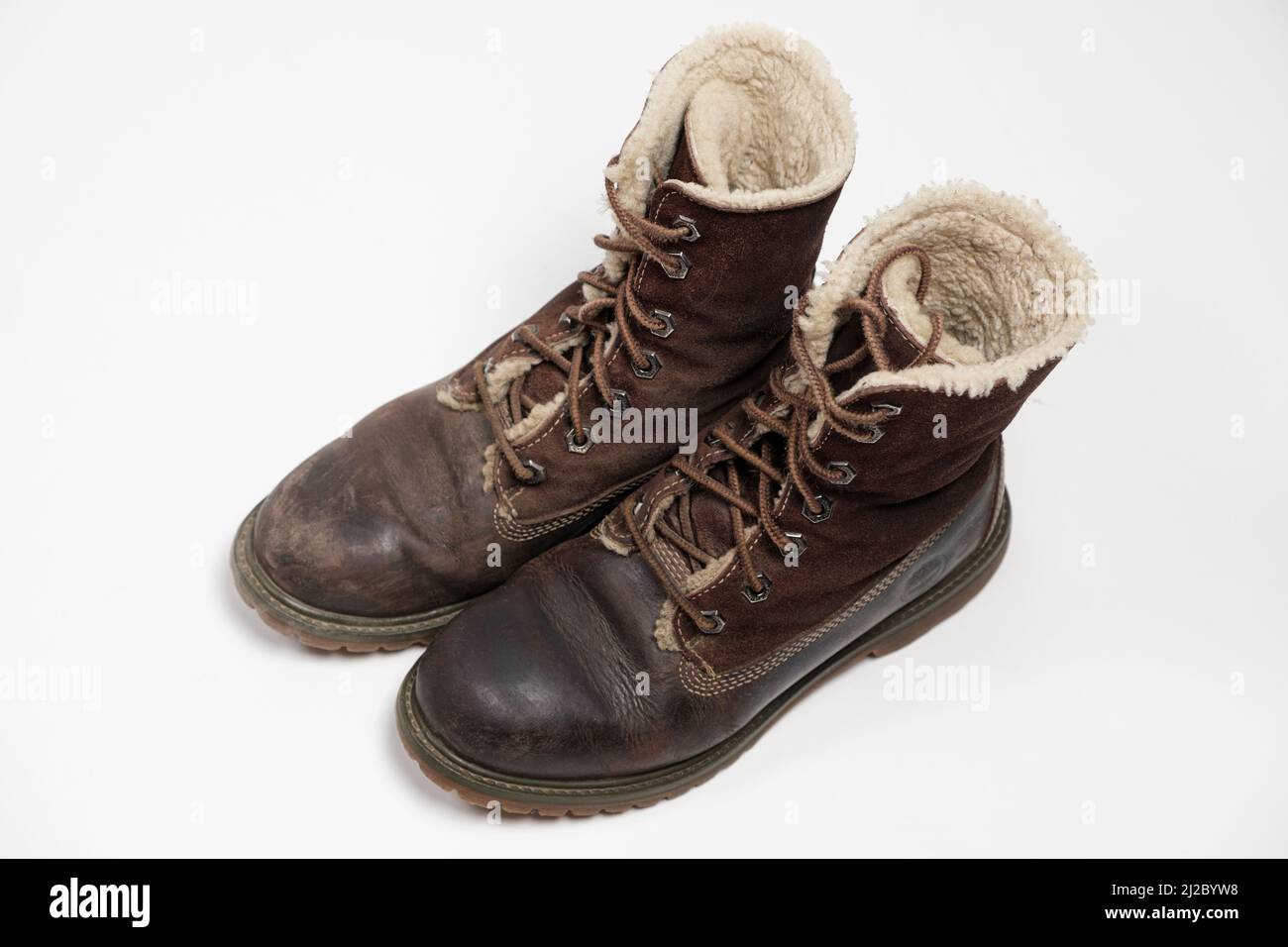 Stivali nubuck marroni - uno sporco, il secondo pulito su sfondo bianco. Cura delle scarpe. Foto Stock