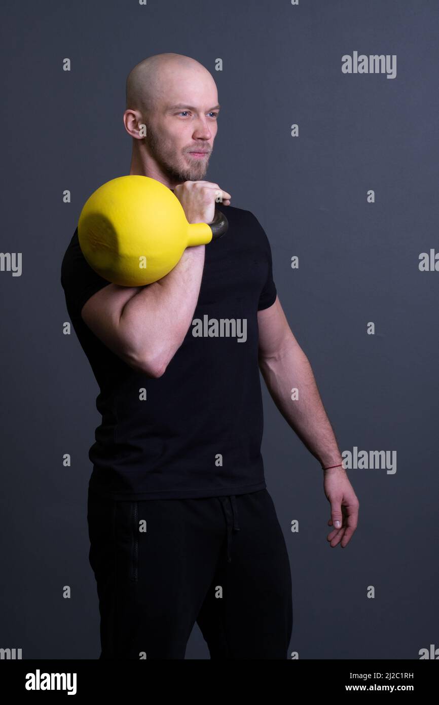 Ragazzo con una palestra gialla kettlebell anonima giovane forza, per uno stile di vita sportivo per il forte e il pavimento sportivo, vietnamita filippino. Sano giù Foto Stock