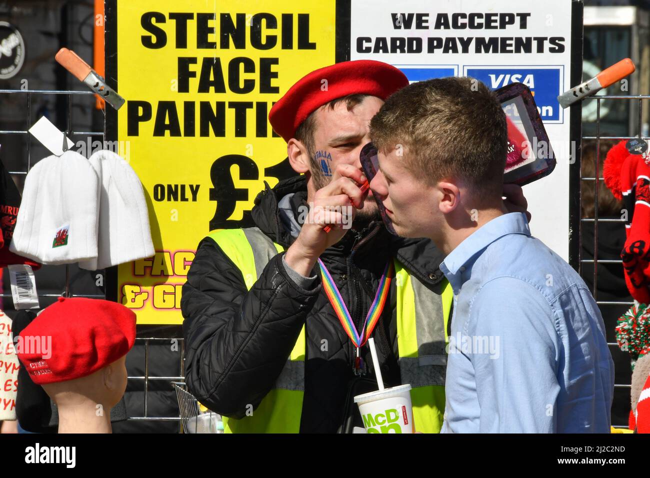 Cardiff, Galles - Marzo 2022: Il fan di Rugby ha un logo a vernice stenciled sul suo volto nel centro di Cardiff il giorno di una partita internazionale di rugby Foto Stock