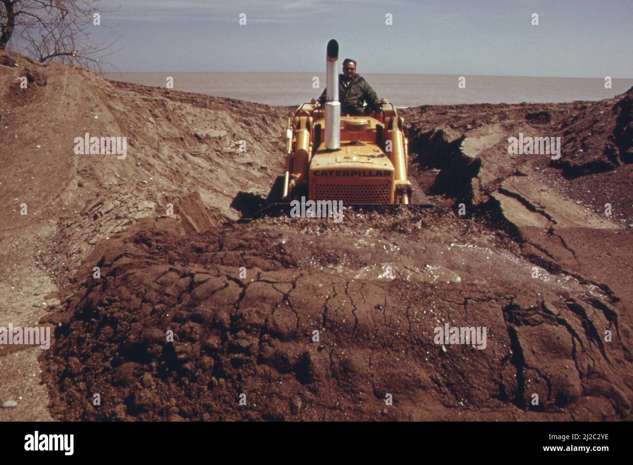 Bulldozer sgorga un canale tra le acque alluvionali intrappolate e il lago Michigan a Zion ca. 1973 Foto Stock