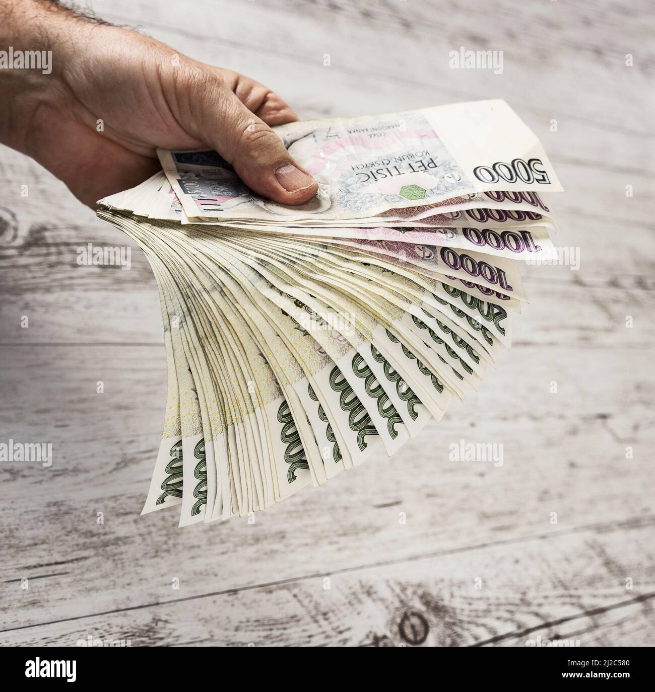 Banconote ceche in un ventilatore nelle mani di un commerciante. Concetto finanziario concettuale.finanziario in valuta ceca. Commercio, finanza, risparmio e concetto di cassa - Foto Stock