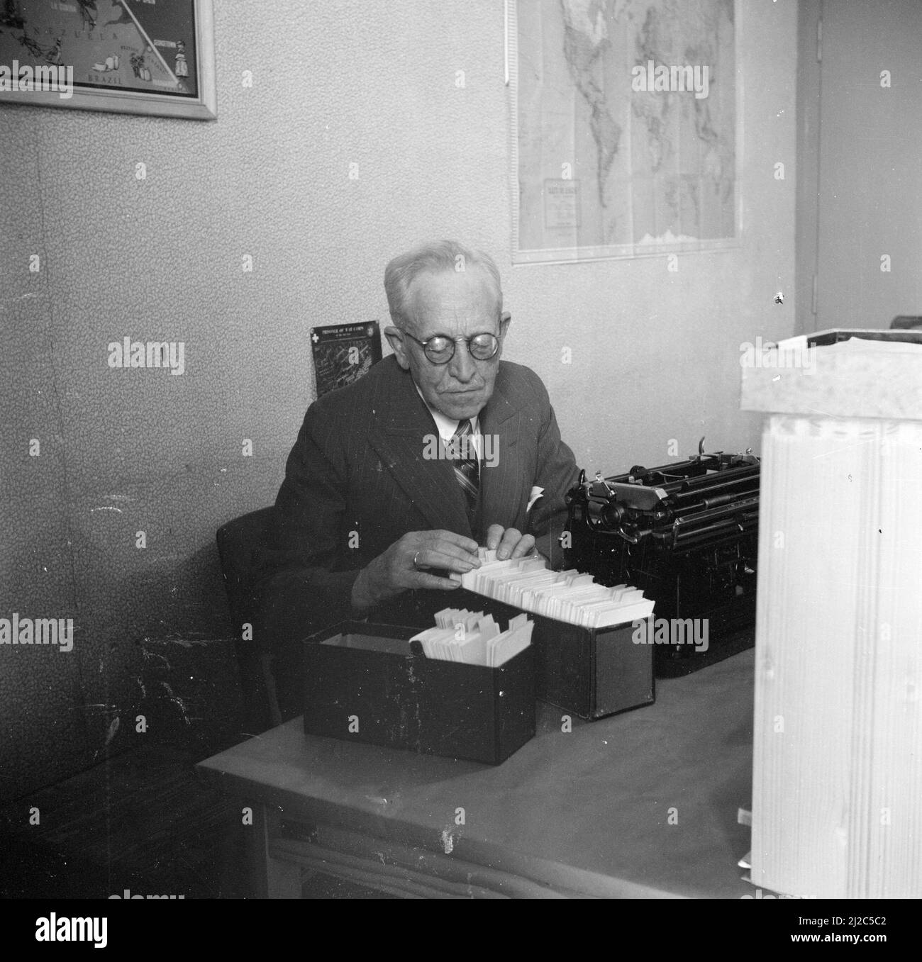 Uomo con un catalogo di carte ca: Maggio 1946 Foto Stock