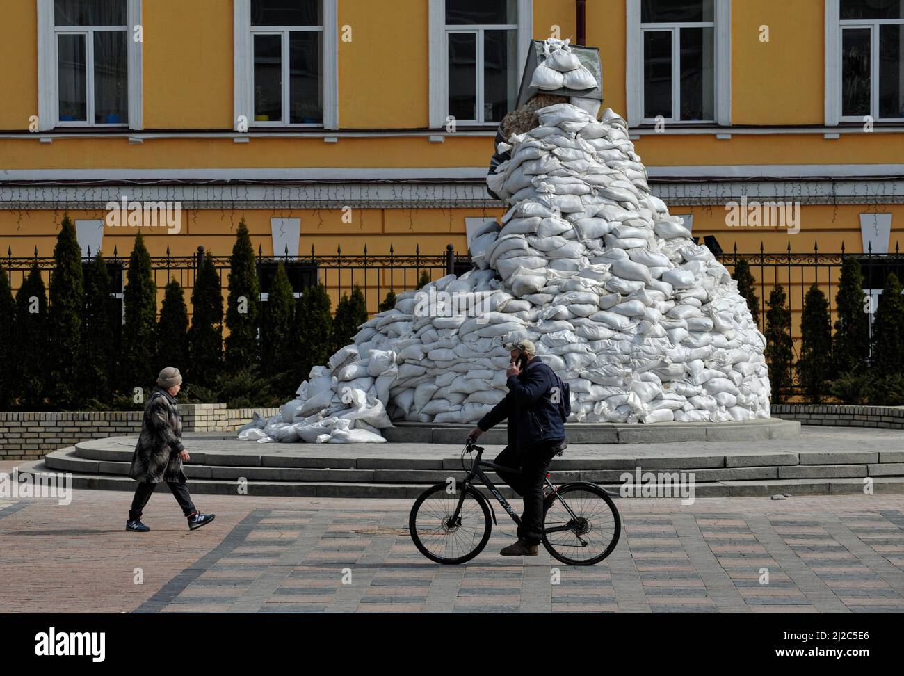 Kiev, Ucraina. 14th Mar 2022. L'uomo passa in bicicletta davanti al monumento di Mykhailo Hrushevsky, noto come accademico, politico, storico e statista ucraino, che era una delle figure più importanti della rinascita nazionale Ucraina dei primi 20th secolo coperto di sacchi di sabbia per proteggerlo dagli attacchi missilistici dell'esercito russo. La Russia ha invaso l'Ucraina il 24 febbraio 2022, scatenando il più grande attacco militare in Europa dalla seconda guerra mondiale (Credit Image: © Sergei Chuzavkov/SOPA Images via ZUMA Press Wire) Foto Stock