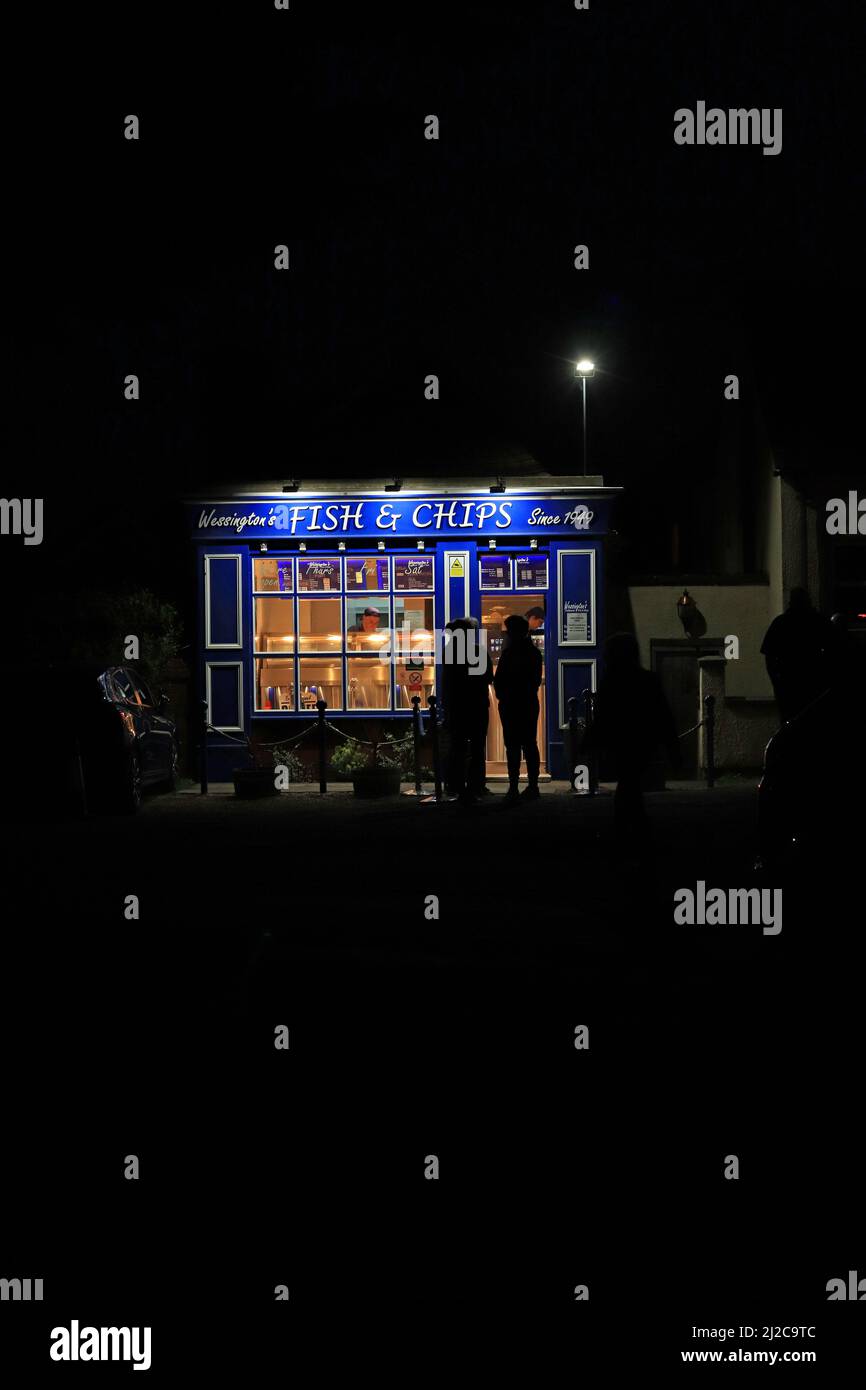 Nel piccolo villaggio di Wessington nel Derbyshire, i clienti di Dales sono in attesa alla luce della sera per ordinare i loro pesci e chip cena Foto Stock