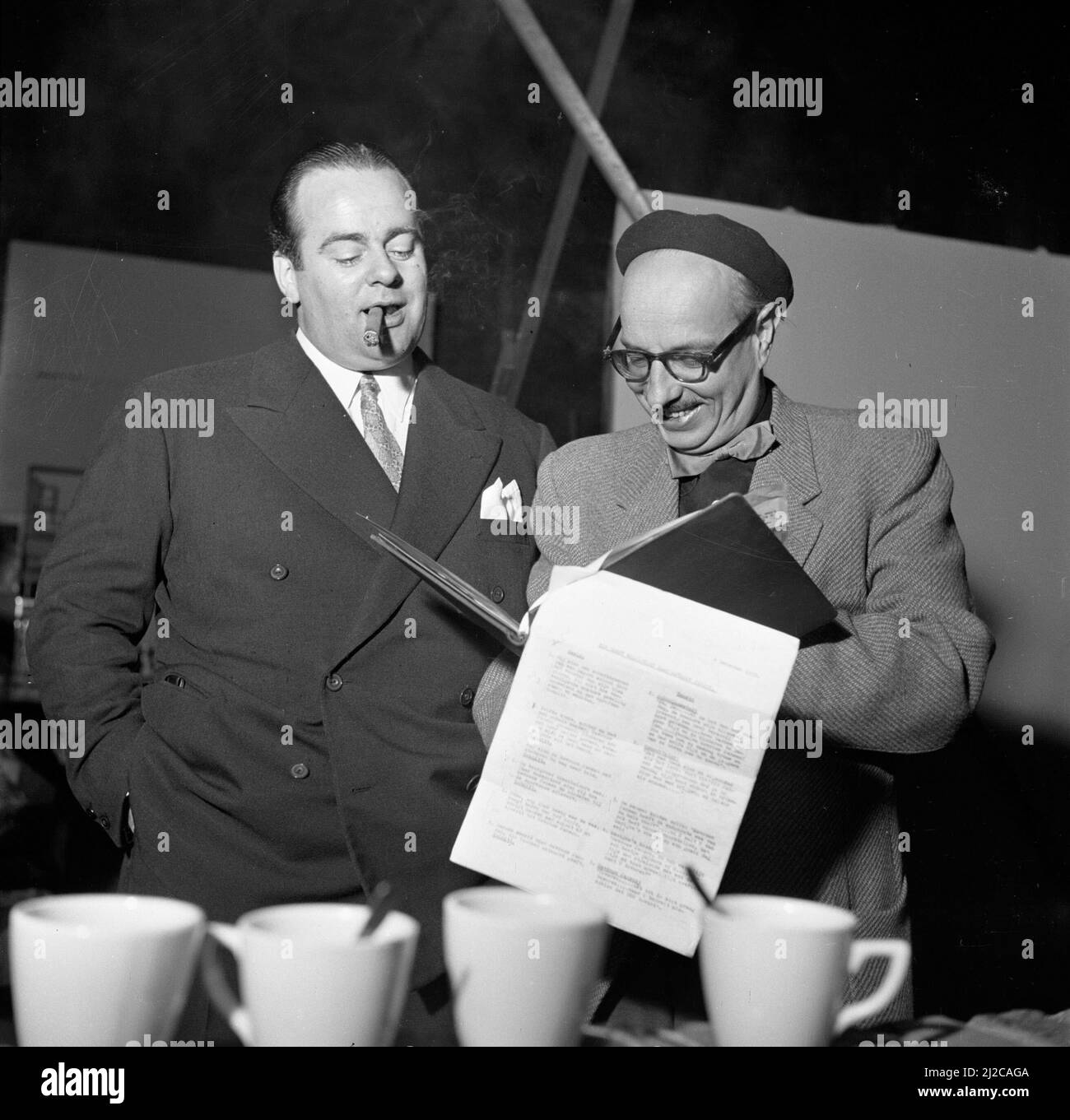 Joop Geesink (l) e Gerard Rutten (r) discutono di una sceneggiatura del film ca: 10 dicembre 1953 Foto Stock