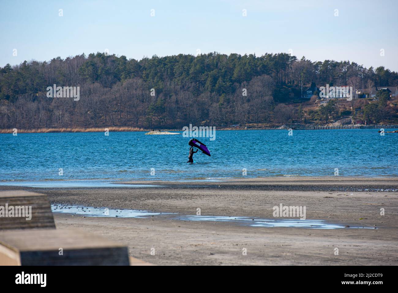 Persona in acqua da una spiaggia che si prepara ad alare foglio Foto Stock