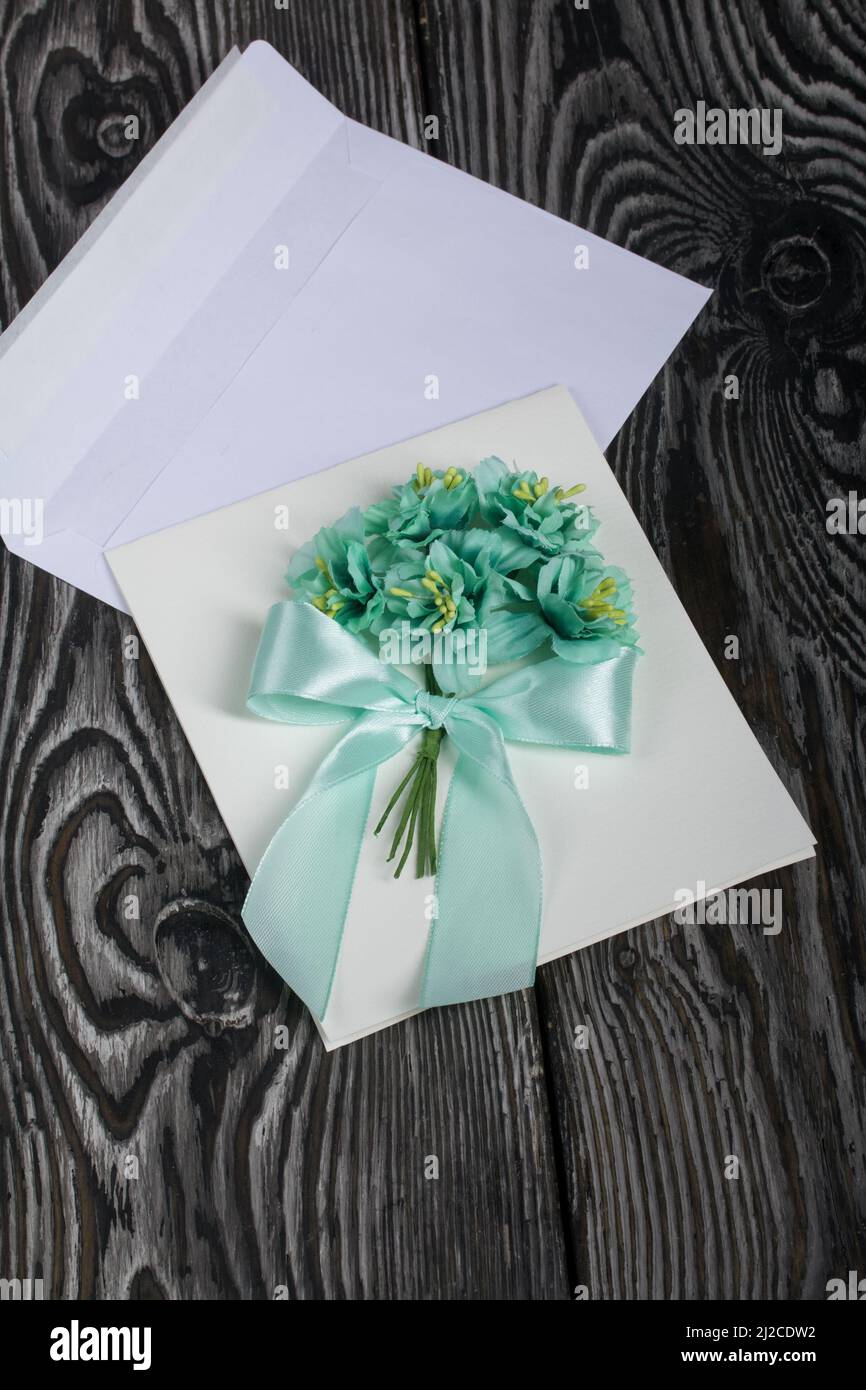 Biglietto d'auguri fatto in casa in toni verdi. Busta per una cartolina. Su tavole di pino. Foto Stock