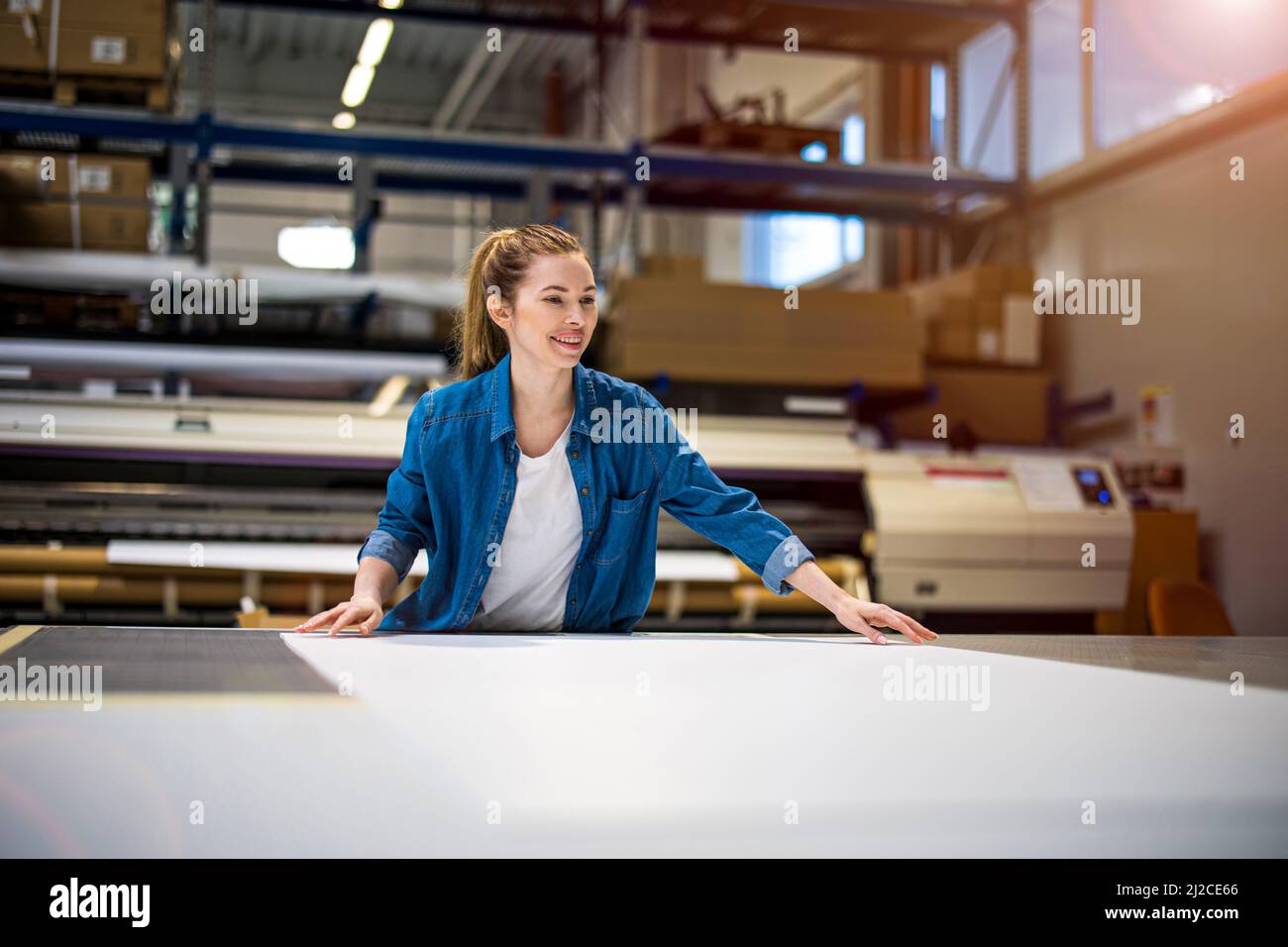 Donna che lavora in una fabbrica di stampa Foto Stock