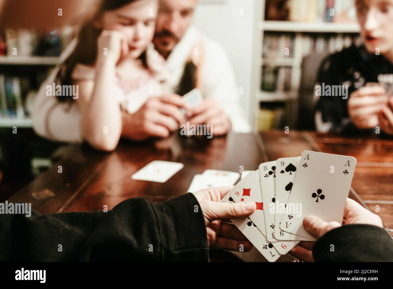 Familie sta giocando le carte la sera Foto Stock