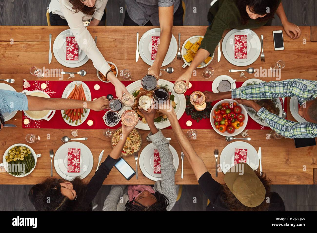 Il cibo è molto buono con gli amici. Scatto corto di un gruppo di persone che fanno un brindisi a un tavolo da pranzo. Foto Stock