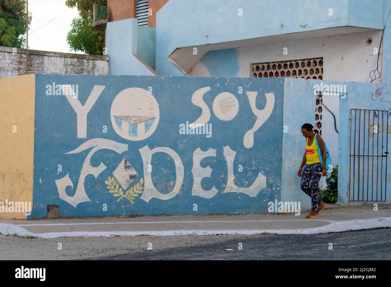 Donna che indossa un paio di infradito cammina accanto a un Yo Soy Fidel, io sono folle (Castro) murale tributo a Trinidad, Cuba. Foto Stock