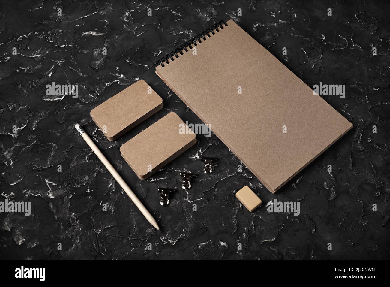 Carta da cancelleria aziendale kraft vuota posta su sfondo di gesso nero. Modello per il design di branding. Marcare a caldo su. Foto Stock