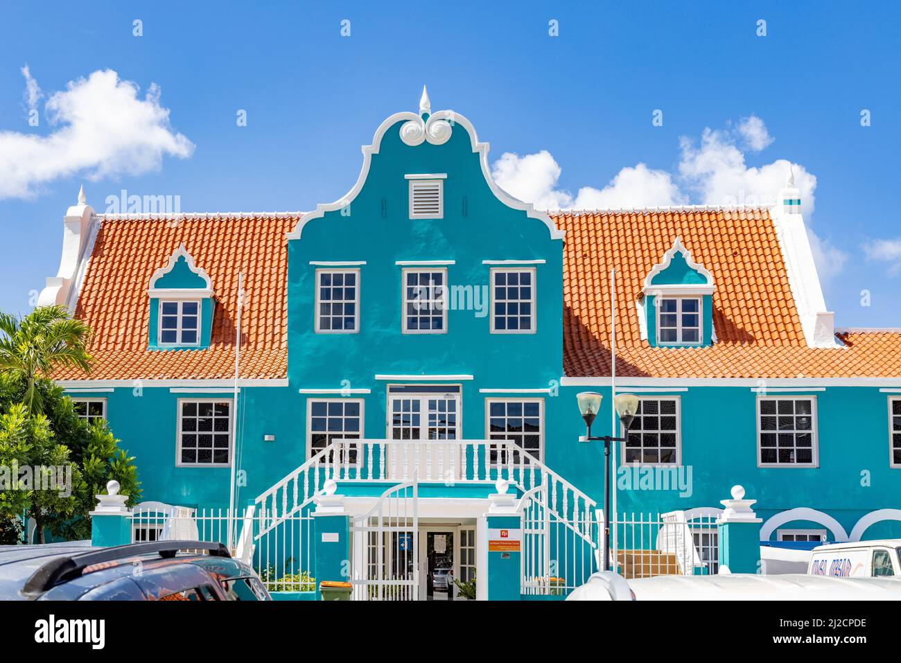 Bell'edificio con una facciata turchese, dettagli bianchi e un tetto arancione a Willemstad, Curacao Foto Stock