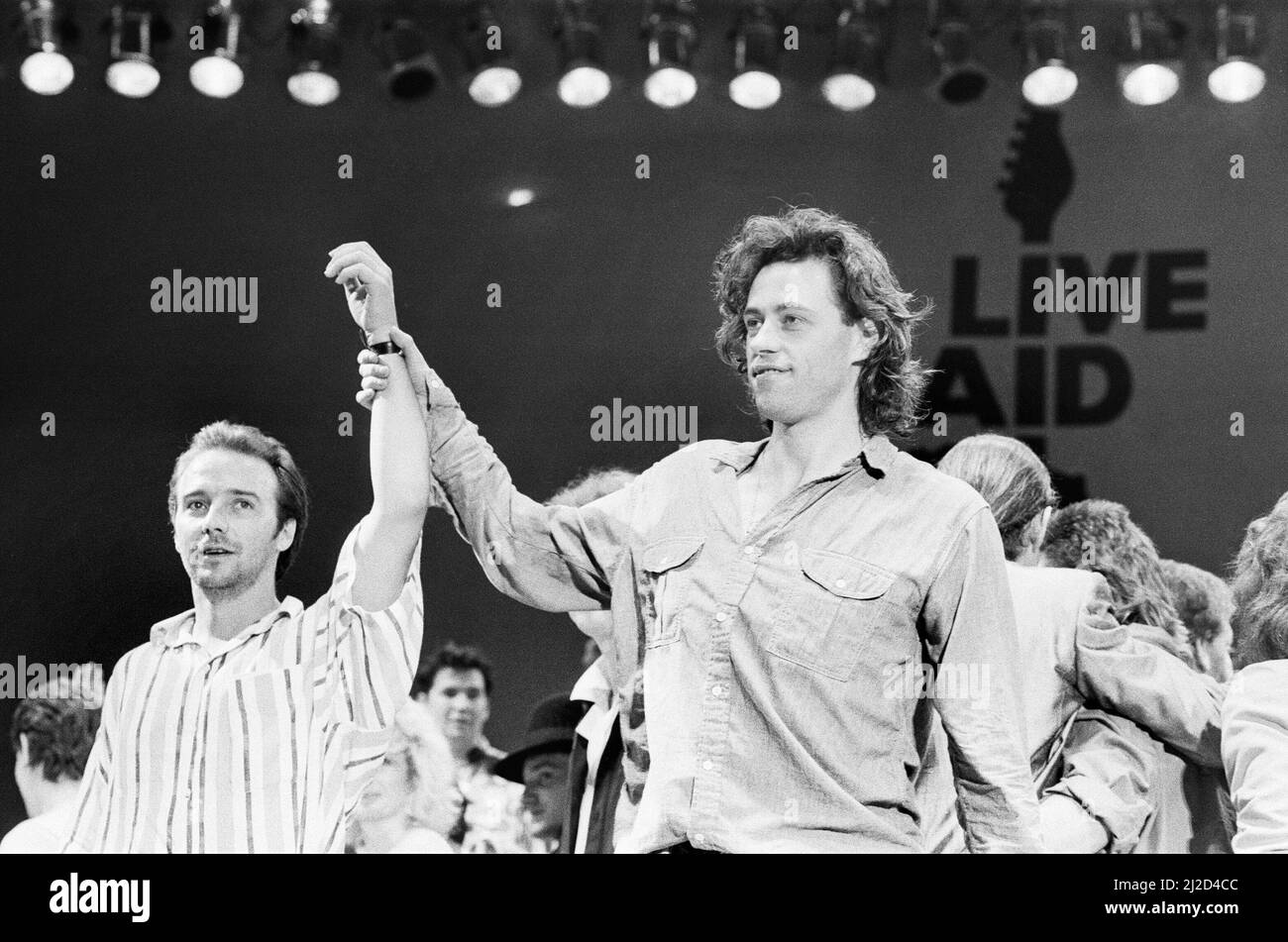 Live Aid due sedi beneficenza concerto tenuto il 13th luglio 1985 al Wembley Stadium di Londra, Inghilterra, e John F. Kennedy Stadium di Philadelphia, Pennsylvania, Stati Uniti. I concerti sono stati organizzati in seguito al singolo Band Aid "so Know its Christmas?" Raccogliere fondi per le vittime della carestia in Etiopia. La foto mostra Midge Ure e Bob Geldof sul palco durante la finale del concerto a Wembley. Foto Stock