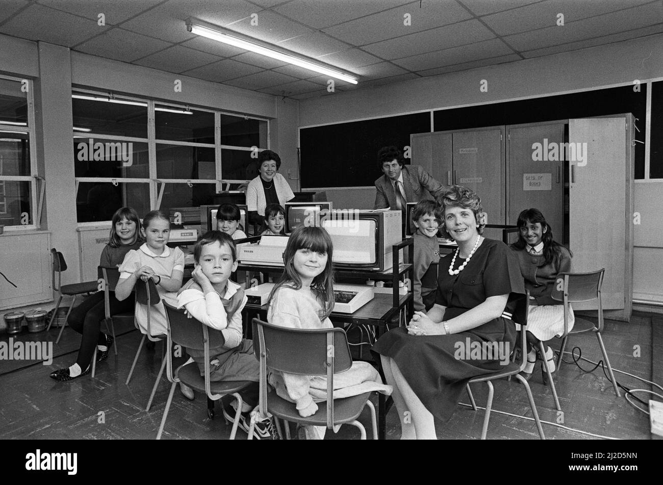 La scuola Dalton Junior dispone ora di un computer per ognuno dei suoi gruppi di quattro anni, grazie agli sforzi di raccolta fondi da parte dei genitori. Negli ultimi 18 mesi sono stati raccolti circa 2.500 ¿dalla scuola¿ Associazione dei genitori-insegnanti, la cui presidente, la signora Joan Dickinson, è raffigurata con alcuni dei bambini. Un computer è stato fornito dal Kirklees Council. 8th maggio 1986. Foto Stock