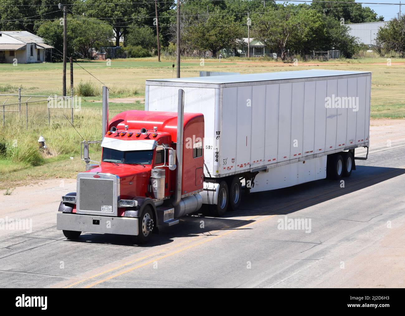 Red semi-Truck guida a sud attraverso Rule Texas - Agosto 2021 Foto Stock