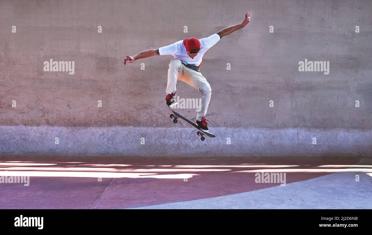 Il cambiamento richiede un salto di fede. Sparato di un giovane che fa trucchi sul suo skateboard allo skatepark. Foto Stock