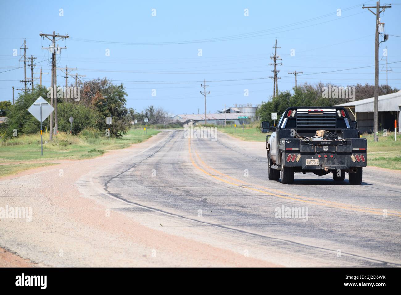 Lavoro pick up camion che guida lungo una strada rurale in Rule Texas - 2021 agosto Foto Stock