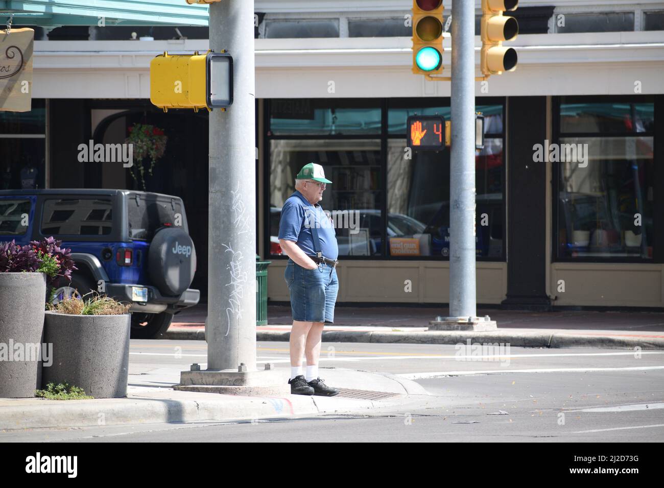 Uomo anziano che indossa pantaloncini e calze bianche si erge su un angolo di strada a Cheyenne Wyoming; agosto 2021 Foto Stock