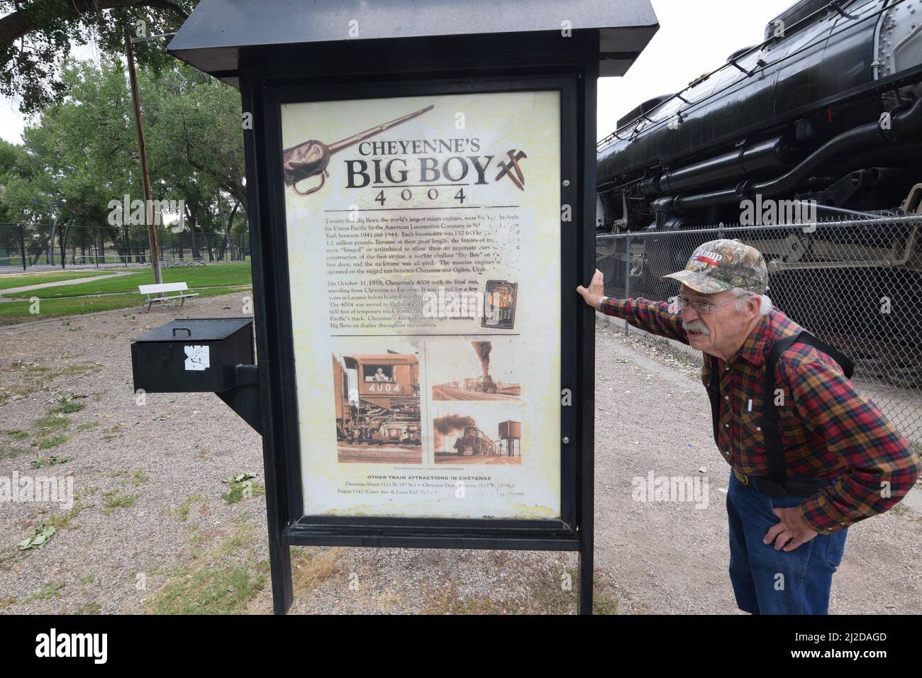 Uomo anziano, cacciato sopra, in piedi accanto ad un cartello per il Big Boy 4004 Train Engine in Cheyenne Wyoming - Agosto 2021 Foto Stock