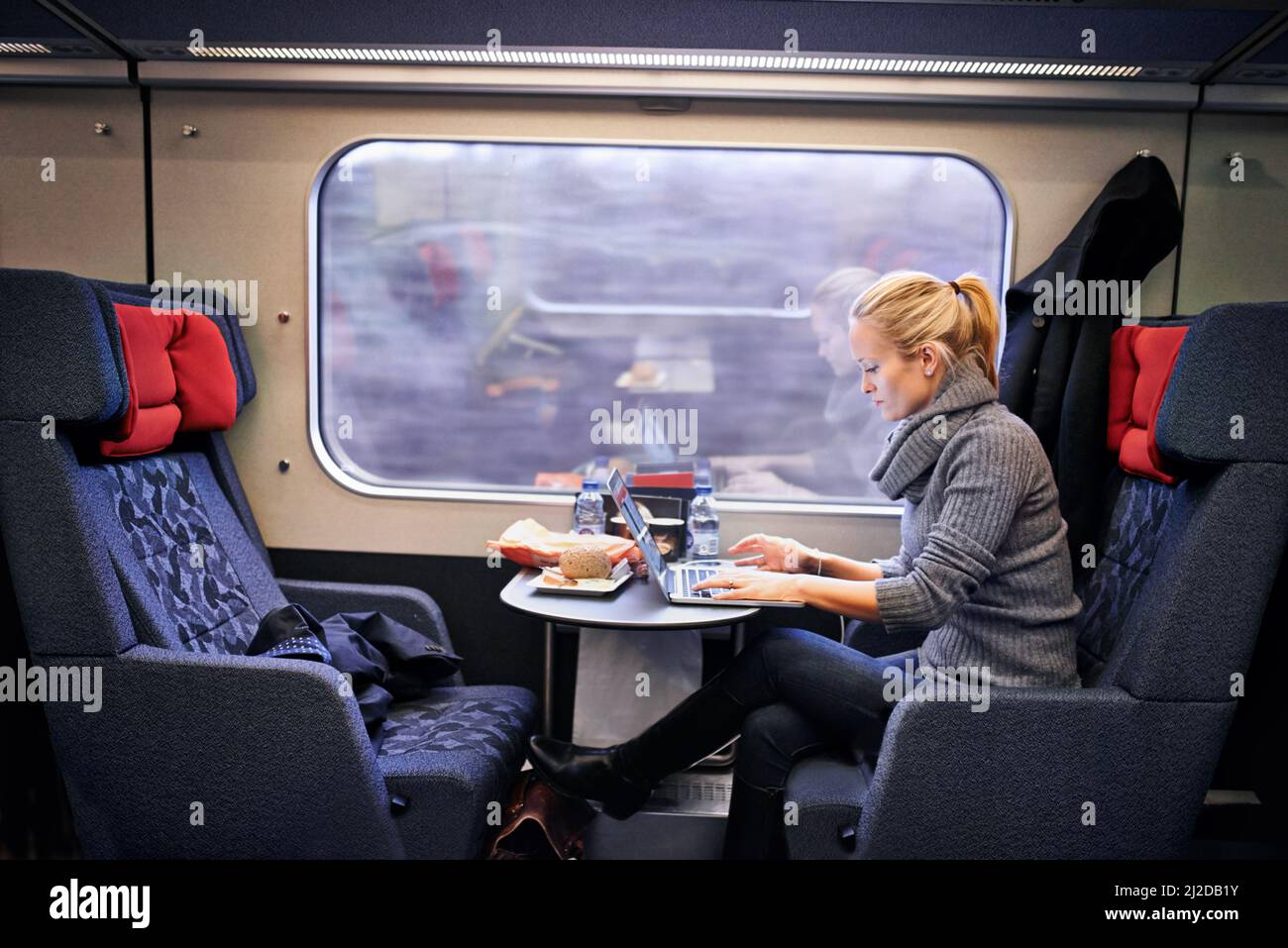 Il tempo è un lusso sul treno. Scatto corto di una giovane donna attraente che viaggia in treno. Foto Stock