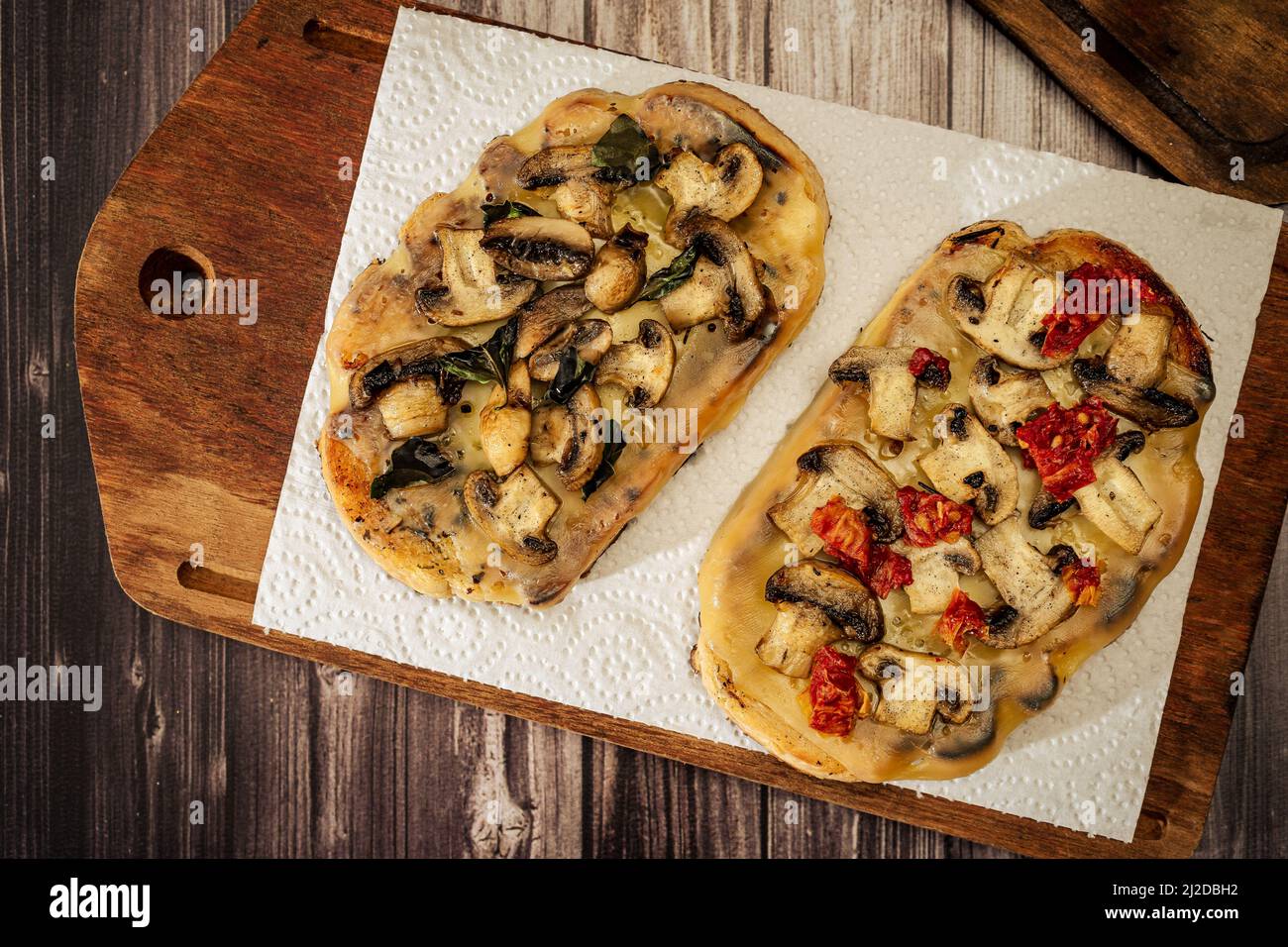 Bruschette grandi con formaggio, funghi, prosciutto e pomodoro in diverse combinazioni. Cucina mediterranea. Vista dall'alto Foto Stock