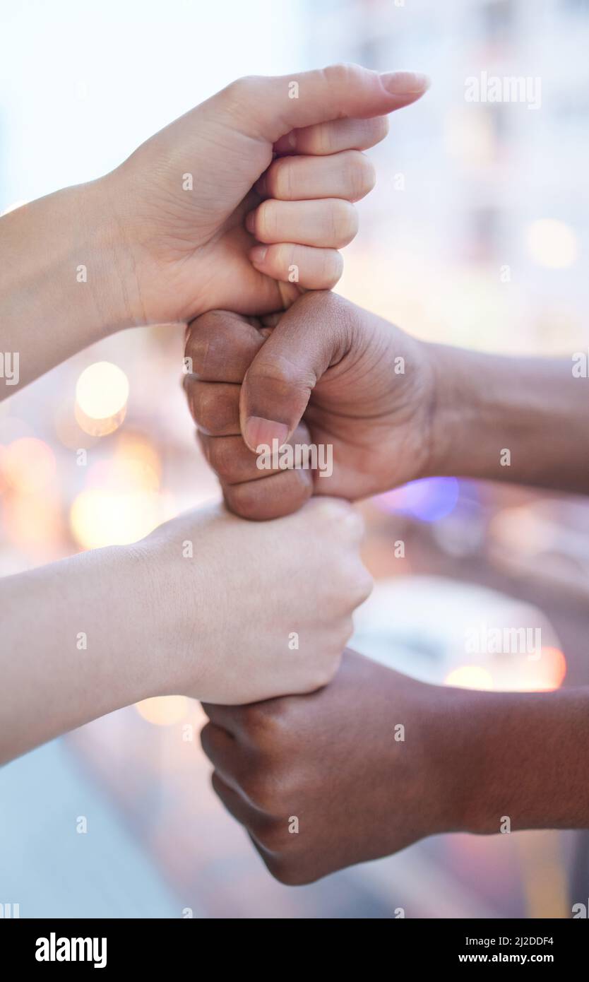 Cresciamo aiutando gli altri. Sparato di due uomini d'affari irriconoscibili che accatastano i loro pugni l'uno sull'altro. Foto Stock