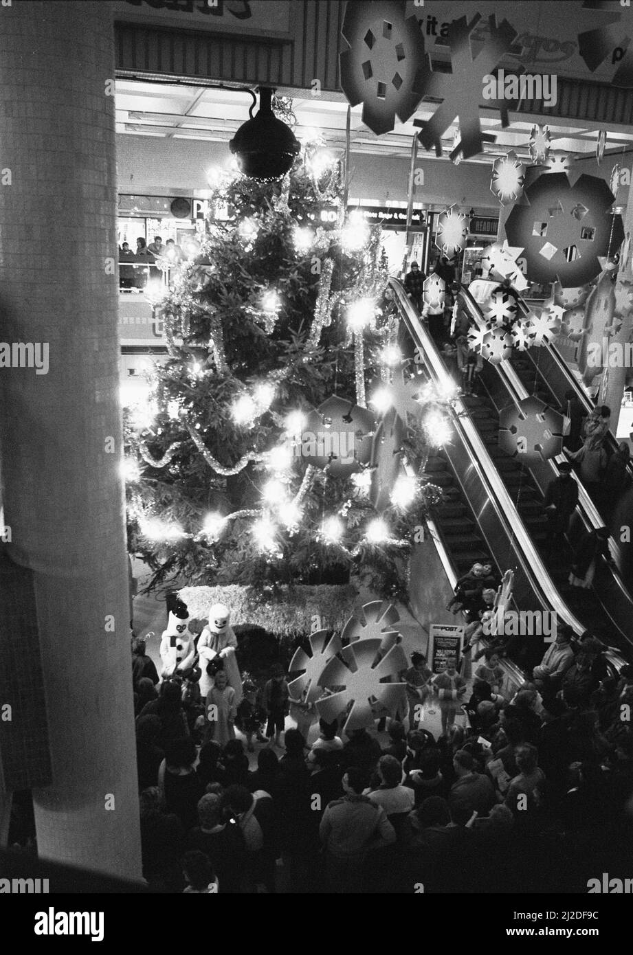 Gli amanti dello shopping di tarda notte ammirano il gigantesco albero di Natale e lo schermo dopo l'accensione della luce di Natale di Reading. 28th novembre 1985 Foto Stock