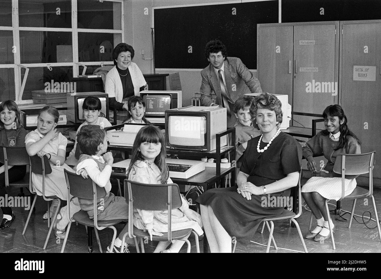 La scuola Dalton Junior dispone ora di un computer per ognuno dei suoi gruppi di quattro anni, grazie agli sforzi di raccolta fondi da parte dei genitori. Negli ultimi 18 mesi sono stati raccolti circa 2.500 ¿dalla scuola¿ Associazione dei genitori-insegnanti, la cui presidente, la signora Joan Dickinson, è raffigurata con alcuni dei bambini. Un computer è stato fornito dal Kirklees Council. 8th maggio 1986. Foto Stock