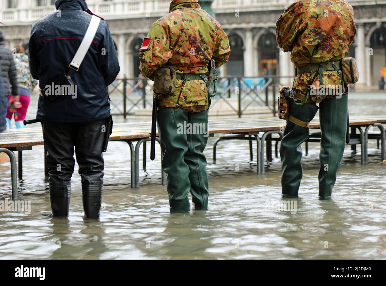 Guardie e soldati italiani con stivali in gomma che pattugliano l'isola di Venezia in Italia in alta marea Foto Stock