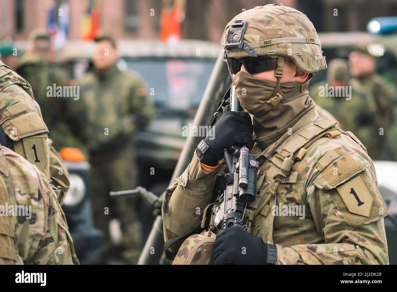 Stati Uniti - Marzo 29 2022: Soldato del corpo Marino degli Stati Uniti con viso coperto e occhiali da sole, fucile e veicolo blindato humvee nella città, Stati Uniti Foto Stock