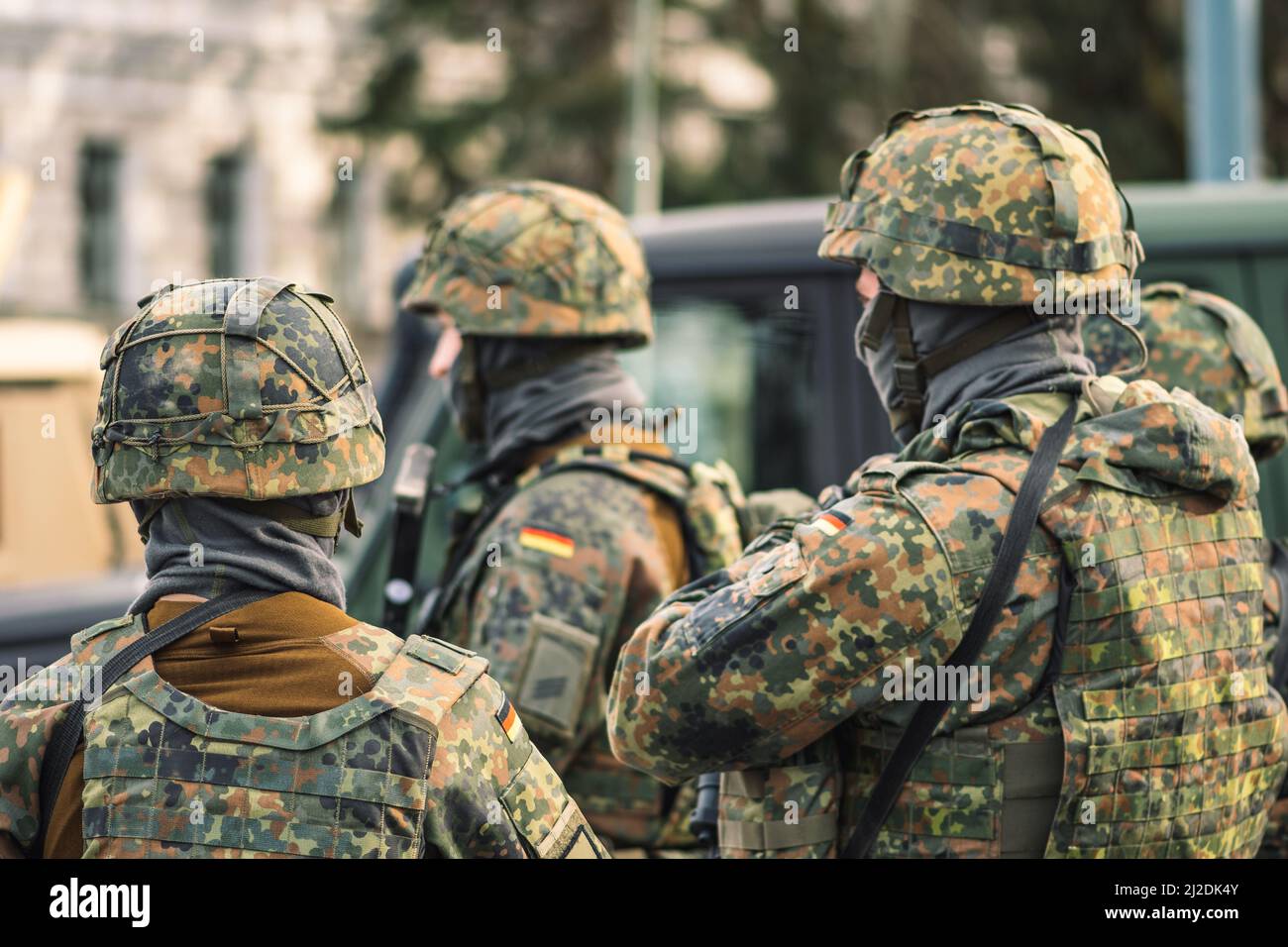 Soldati dell'esercito tedesco con armi, caschi e veicoli militari, truppe pronte per gli esercizi o la guerra in città Foto Stock