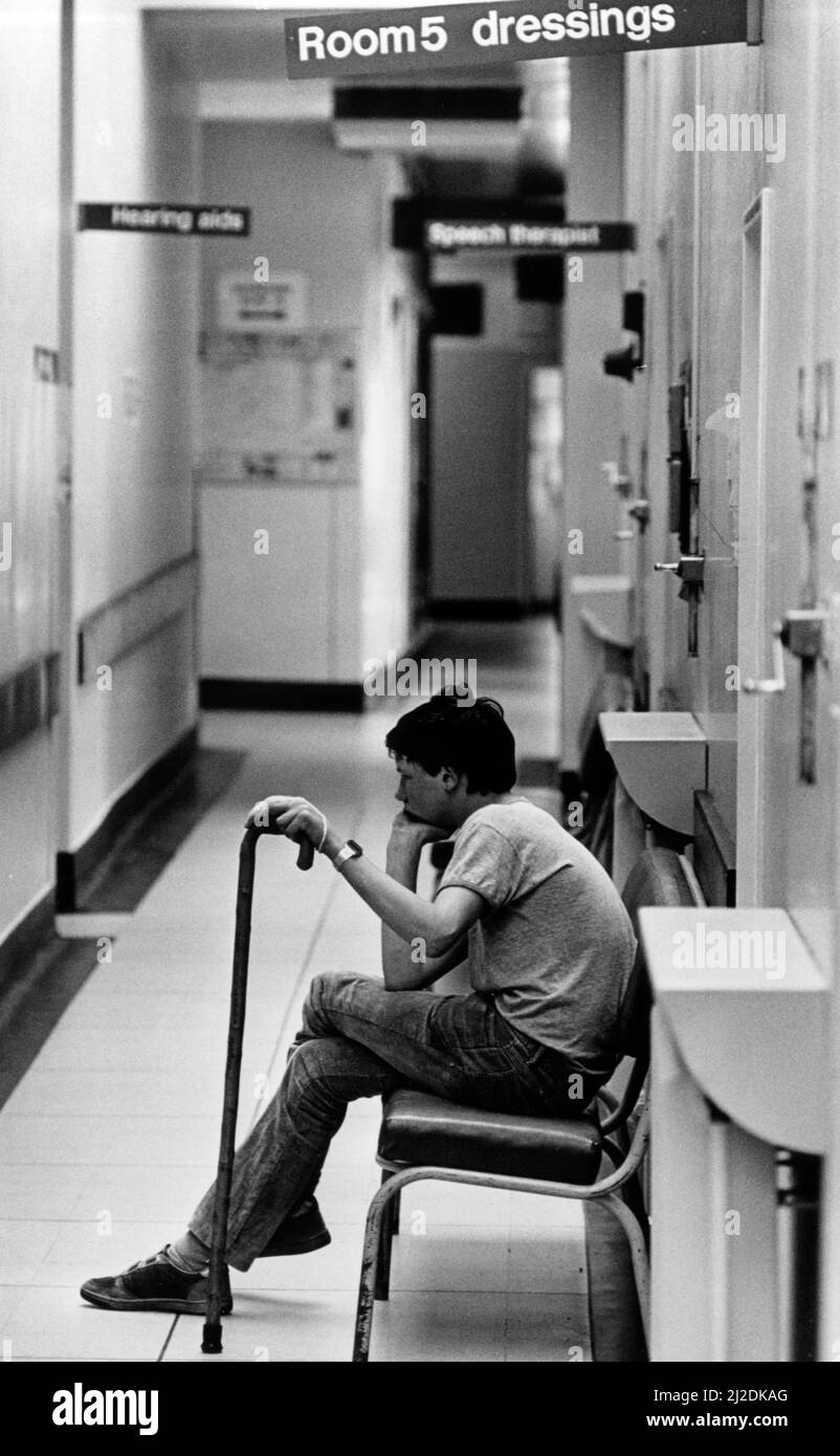Casualty, Coventry and Warwickshire Hospital, Coventry, West Midlands, 10th giugno 1985. Un paziente giovane annoiato contempla una lunga attesa per il trattamento Foto Stock