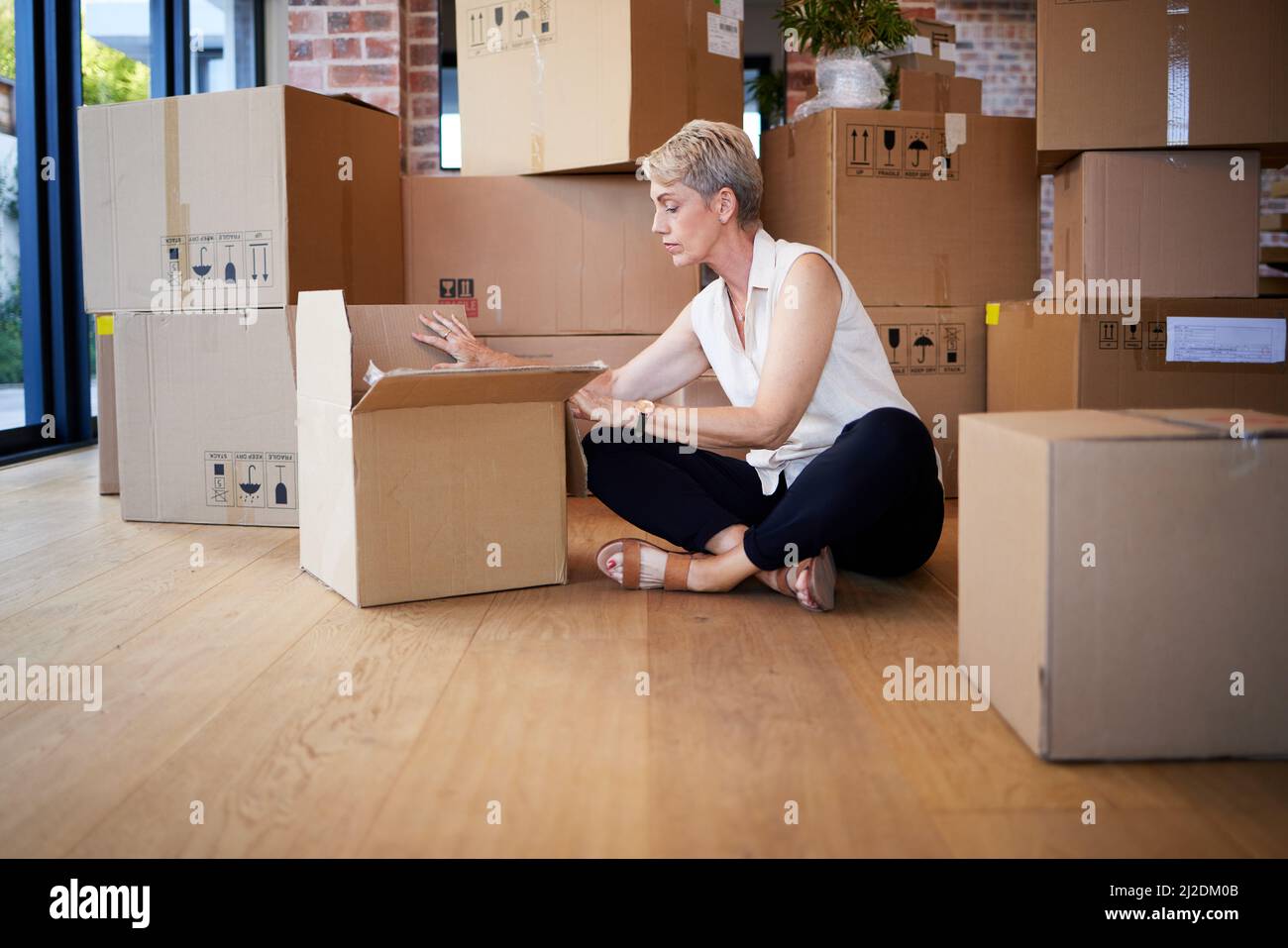 La mia casa, il mio cuore. Shot di una donna matura disimballaggio scatole in movimento giorno. Foto Stock