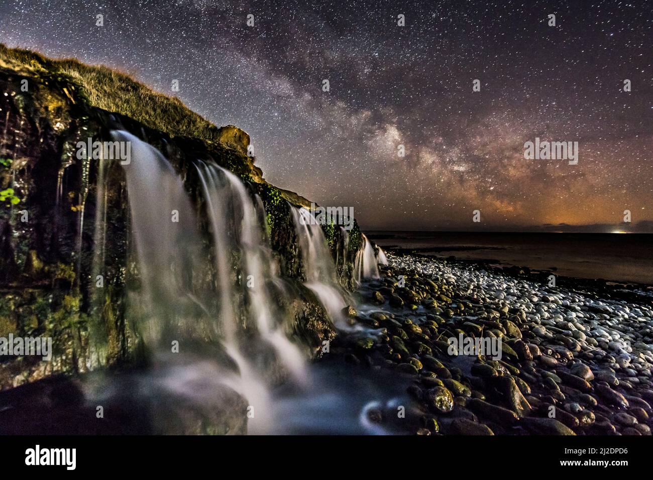 Osmington Mills, Dorset, Regno Unito. 1st aprile 2022. Meteo Regno Unito. La Via Lattea brillantemente nel freddo cielo notturno limpido sopra una cascata sulla spiaggia di Osmington Mills vicino a Weymouth sulla Costa Dorset Jurassic. Picture Credit: Graham Hunt/Alamy Live News Foto Stock