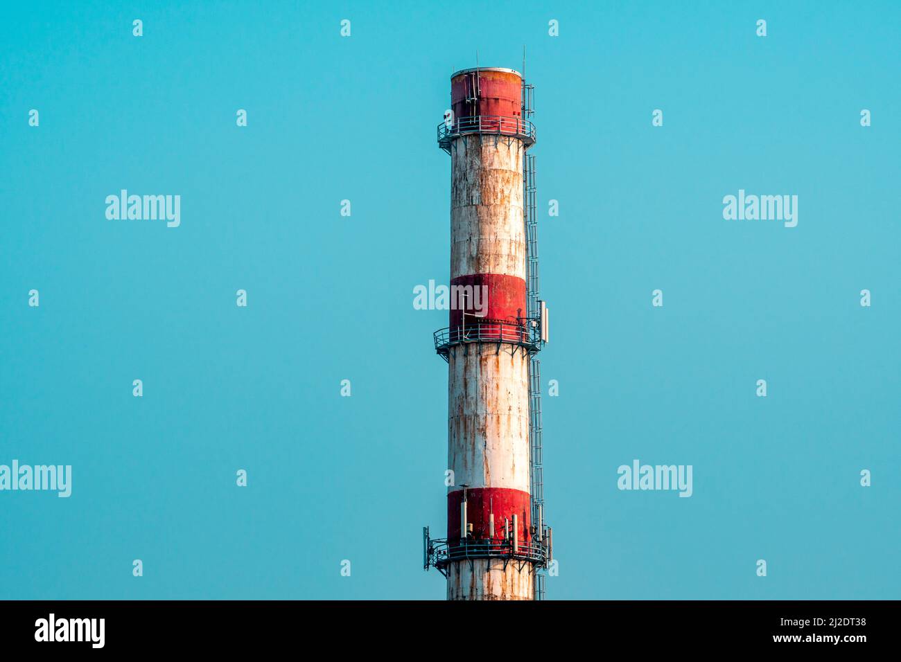 Vecchio camino dipinto di rosso e bianco contro il cielo blu Foto Stock