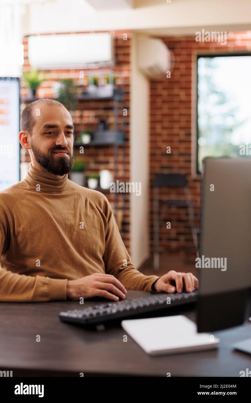 Consulente dell'agenzia di marketing seduto alla scrivania mentre sviluppa la campagna di promozione del progetto di avvio. Imprenditore aziendale che ricerca idee di investimento e strategie finanziarie. Foto Stock