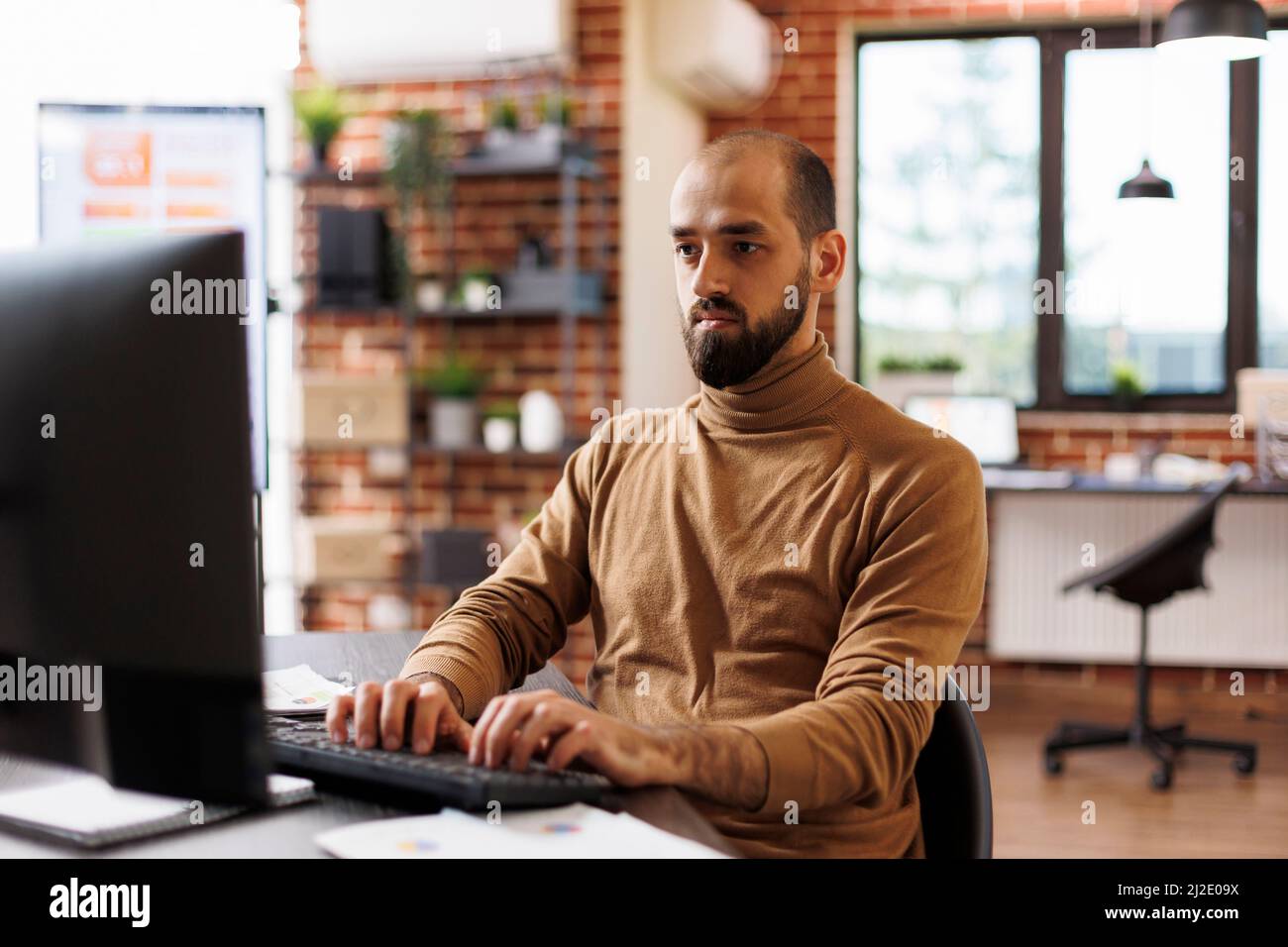 Responsabile di progetto sicuro che lavora sulla strategia di affari e l'analisi finanziaria mentre siede l'ufficio dell'azienda. Dipendente dell'agenzia di sviluppo che sviluppa soluzioni di marketing e idee di avvio. Foto Stock