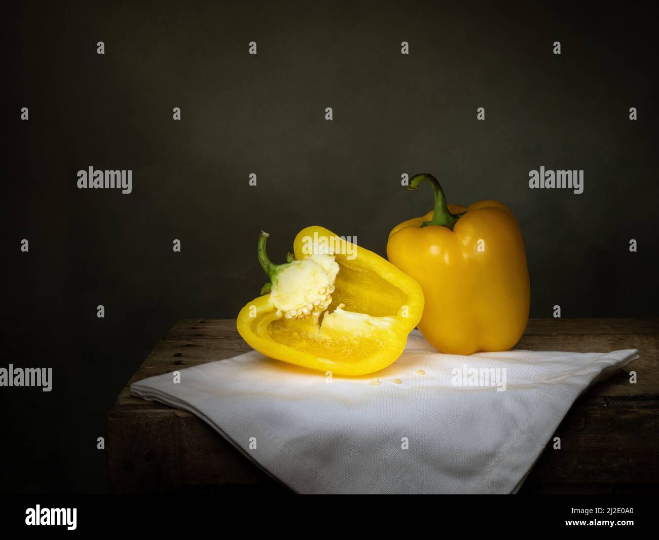 Ancora vita con peperoni gialli, un taglio, chiaroscuro. Foto Stock