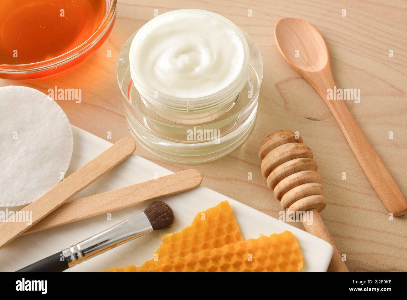 Cosmetici con estratti di miele con utensili su tavola in legno da vicino. Composizione orizzontale. Vista dall'alto. Foto Stock