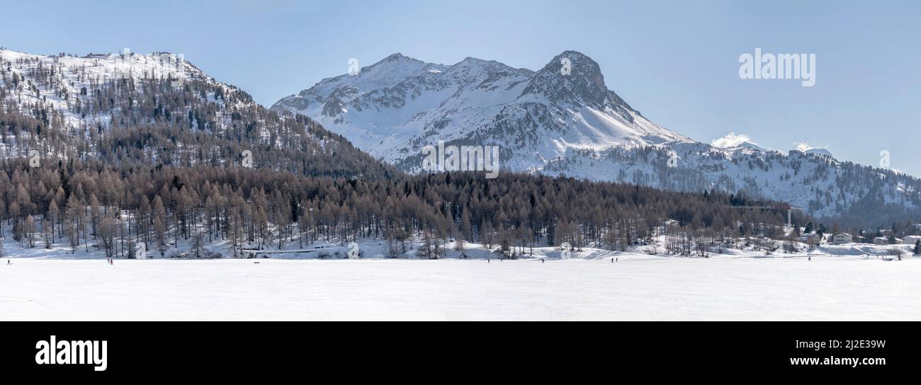 Paesaggio invernale con picco di piz Bacun e lago ghiacciato, girato in luce brillante vicino Maloja, Grigioni, Svizzera Foto Stock