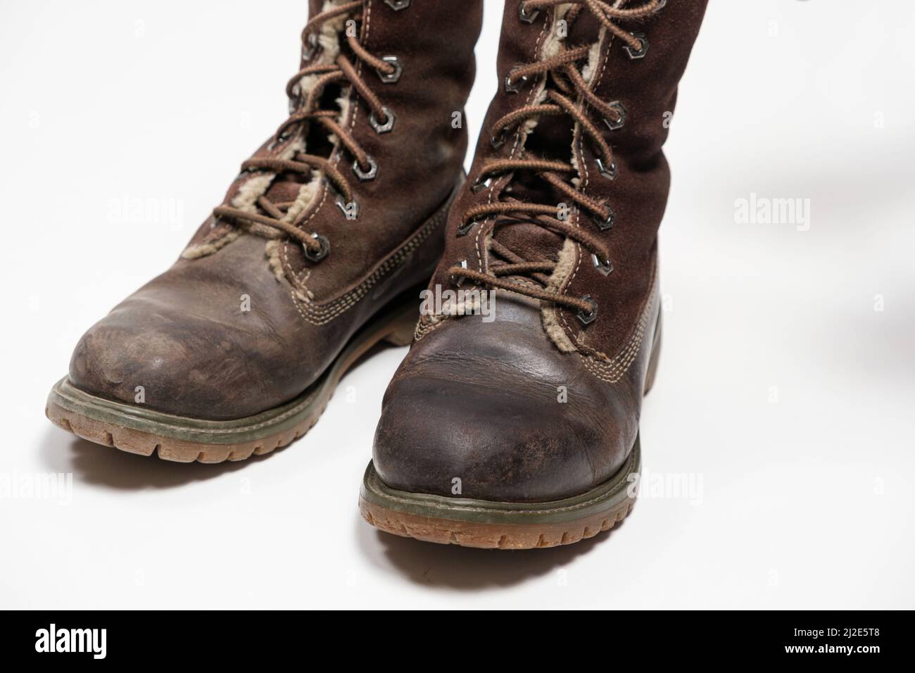 Stivali nubuck marroni - uno sporco, il secondo pulito su sfondo bianco. Cura delle scarpe. Foto Stock