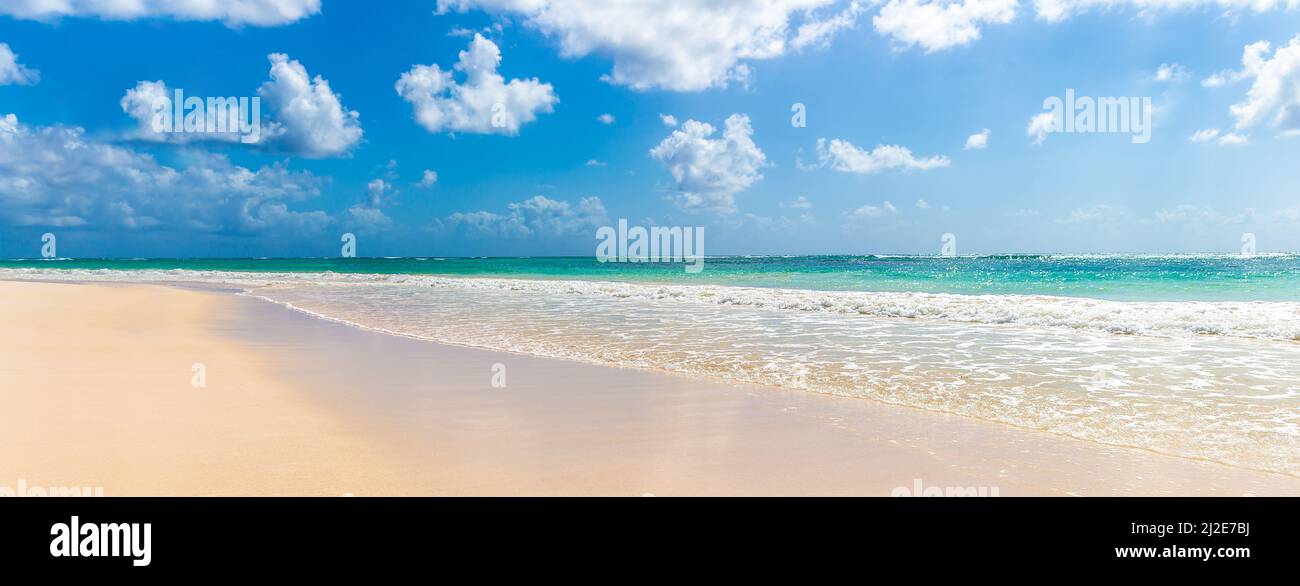 Bandiera di una grande spiaggia di sabbia vuota e un mare caldo e pulito e cielo blu con poche nuvole come simbolo di una destinazione turistica estiva iconica. Foto Stock