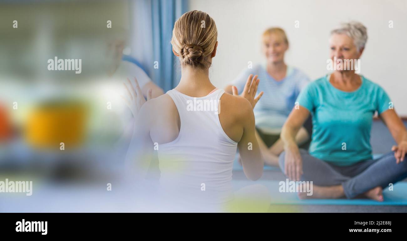 Effetto sfocato con spazio copia contro l'allenatore femminile di yoga e il gruppo di persone anziane che svolgono yoga Foto Stock