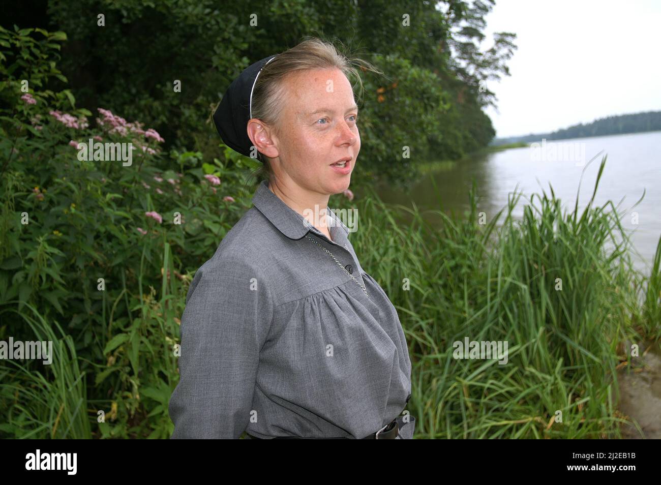 Augustów Polonia, Polen, Polska, Ritratto di una suora sullo sfondo del lago. Porträt einer Nonne auf dem Hintergrund des See. 湖背景上的修女肖像。Zakonnica Foto Stock