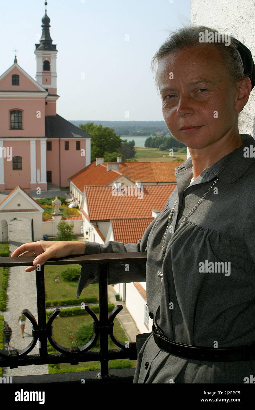 Wigry, Podlasie, Polonia, Polen, Polska, Ritratto di una suora sullo sfondo dell'ex monastero camaldolese. Portret zakonnicy zakonnica Foto Stock