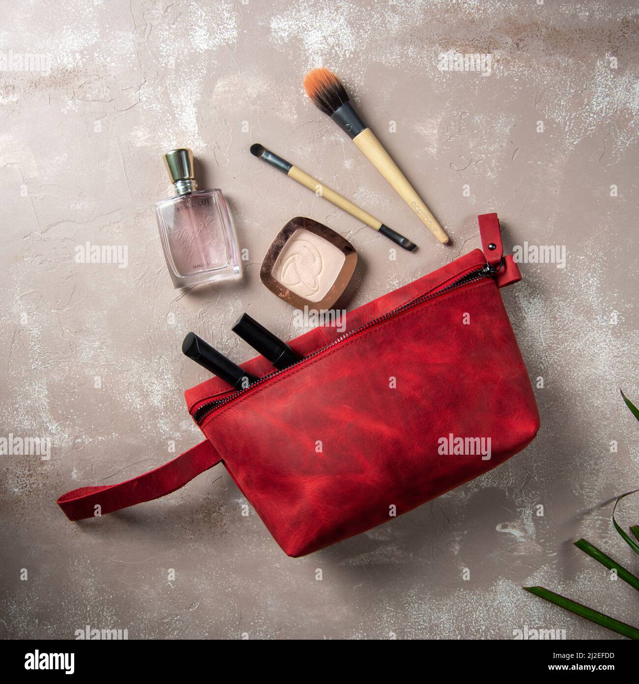 borsa per il trucco in pelle rossa fatta a mano con articoli per il trucco Foto Stock