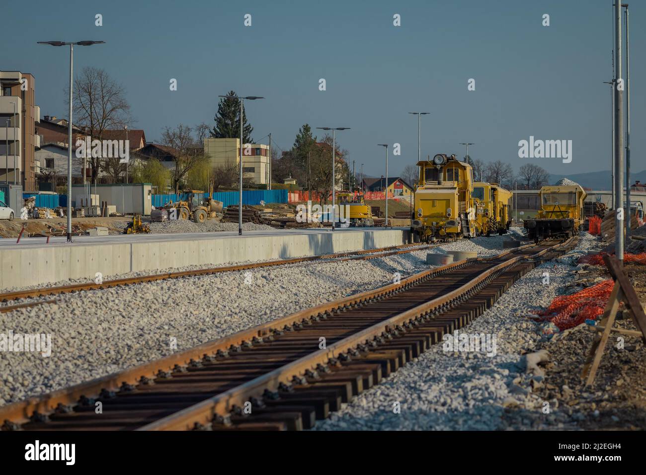 Stazione ferroviaria di Grosuplje in fase di ristrutturazione. Nuovi cingoli nuovi posti accanto alla piattaforma passeggero, aratro ferroviario visibile, manomissione e alcuni carri. Foto Stock