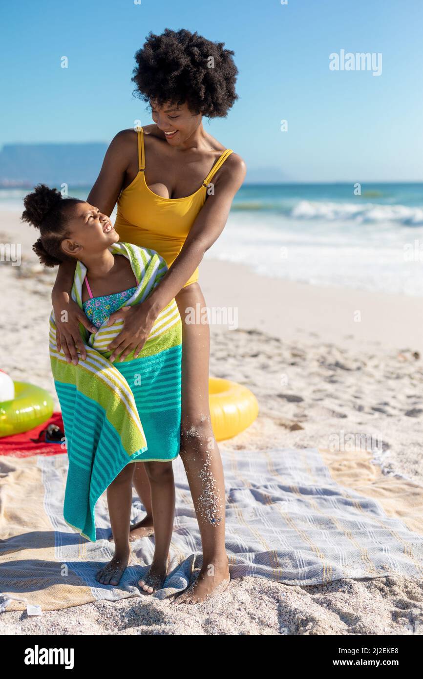 Felice madre e figlia afroamericana che si guardano mentre si alza in spiaggia Foto Stock