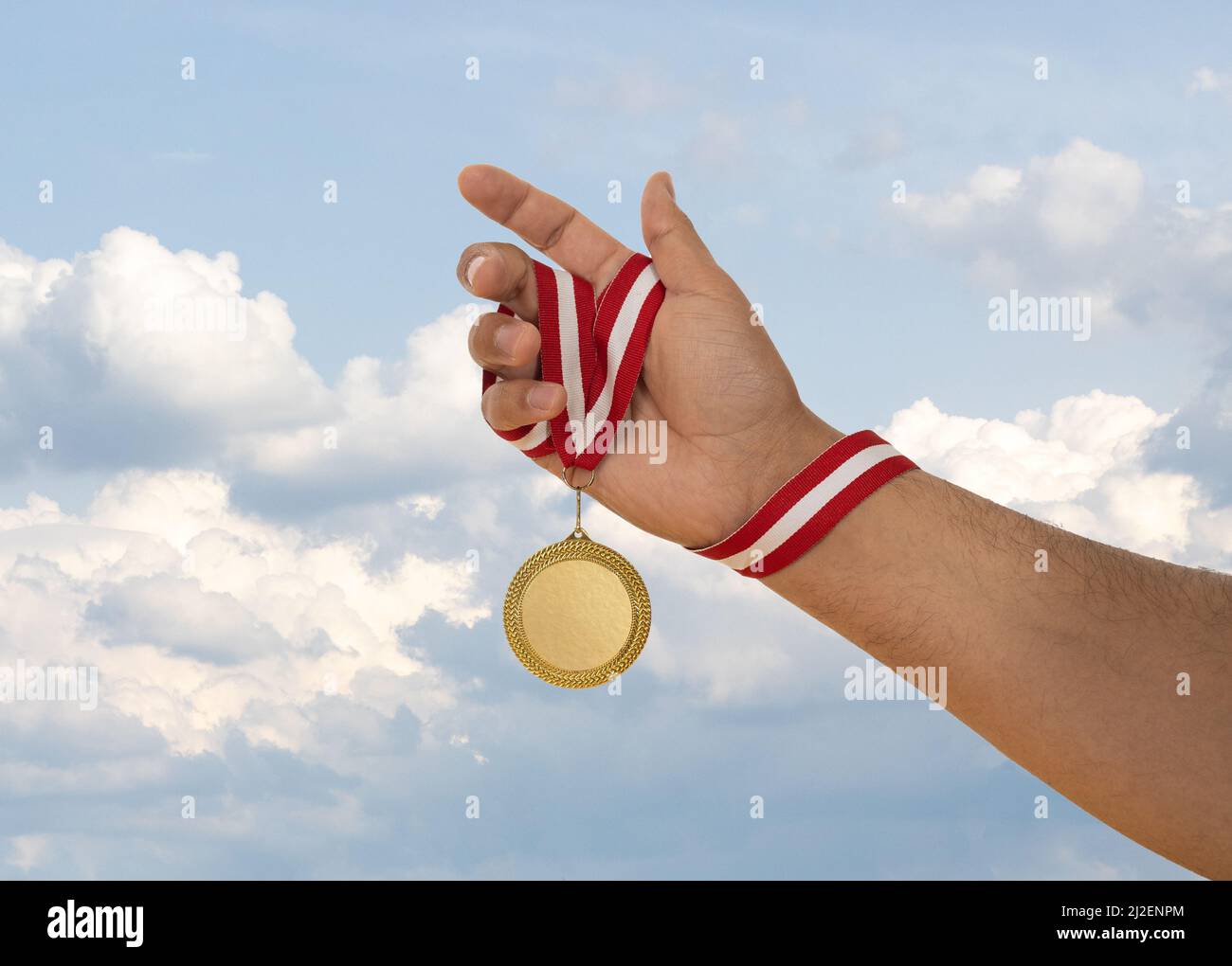 Uomo che alza la mano e tiene medaglia d'oro. Concetto di ambizione perseveranza e vittoria. Foto Stock